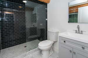 Bathroom with walk in shower, tile patterned floors, toilet, and vanity