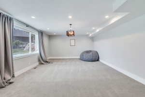 Workout area featuring a notable chandelier and light colored carpet