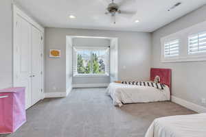 Carpeted bedroom featuring a closet and ceiling fan