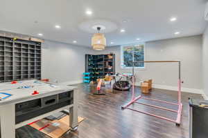 Game room with dark wood-type flooring