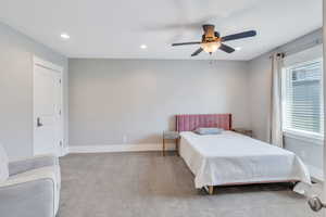 Carpeted bedroom featuring ceiling fan