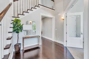 Foyer entrance featuring dark hardwood / wood-style floors and a high ceiling