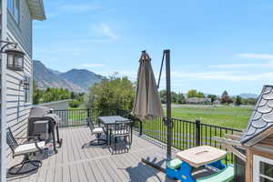 Wooden terrace featuring a mountain view and a yard