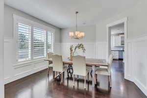 Dining space featuring an inviting chandelier and dark hardwood / wood-style flooring