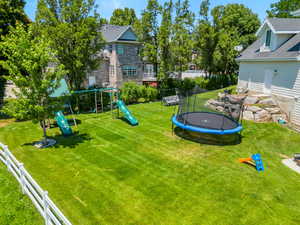 View of yard with a trampoline and a playground