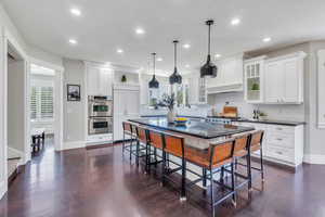 Kitchen with backsplash, a center island, white cabinets, and a kitchen breakfast bar