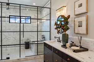 Bathroom with tile patterned flooring, vanity, and a shower with shower door