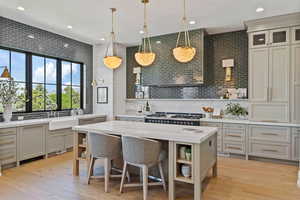 Kitchen with a center island, a breakfast bar, light hardwood / wood-style flooring, and tasteful backsplash