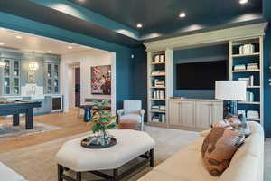 Living room featuring light wood-type flooring, built in features, and beverage cooler