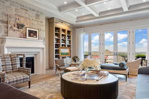 Living room featuring a healthy amount of sunlight, coffered ceiling, beamed ceiling, and wood-type flooring