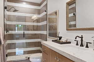 Bathroom with vanity, toilet, and walk in shower