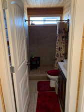 Bathroom featuring vanity, toilet, tile patterned flooring, and a shower with curtain