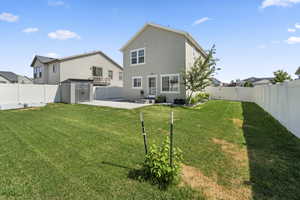 Rear view of property with a patio and a lawn