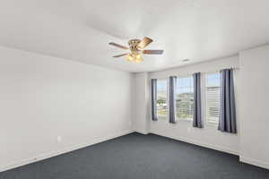 3rd upstairs bedroom with ceiling fan and dark carpet