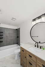 Full bathroom featuring tile patterned flooring, toilet, vanity, and tiled shower / bath