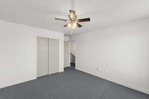 2nd upstairs bedroom with dark-colored carpet, ceiling fan, and a closet