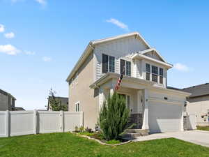 View of property with a garage and a front lawn