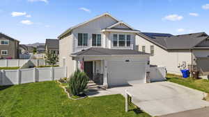 View of front of home with a garage and a front lawn