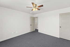 3rd upstairs bedroom with dark carpet and ceiling fan