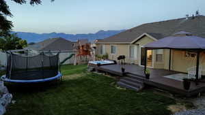 Exterior space featuring a trampoline and a deck with mountain view