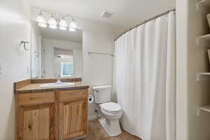 Bathroom featuring vanity, toilet, and tile patterned floors