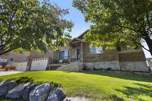 View of front of property with a garage and a front lawn