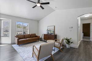 Living room with wood-type flooring, ceiling fan, and lofted ceiling