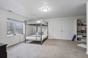 Carpeted bedroom with a closet