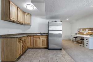 Kitchen with tile, carpet, stainless steel refrigerator, and sink