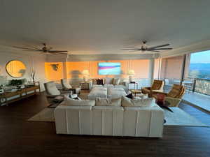 Living room featuring ceiling fan and dark wood-type flooring