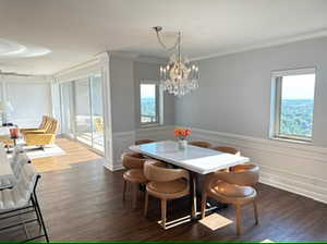 Dining space featuring an inviting chandelier, dark hardwood / wood-style flooring, and ornamental molding