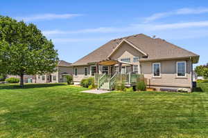 Back of property with a deck, a lawn, and a pergola