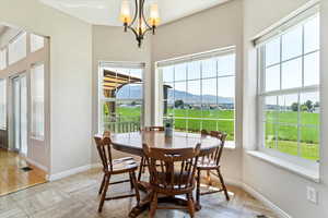 Dining area with a mountain view, a notable chandelier, and light hardwood / wood-style flooring