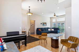 Living room with ceiling fan and hardwood / wood-style floors