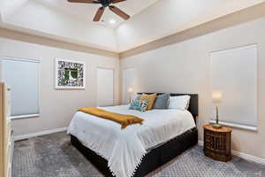 Bedroom featuring carpet floors, ceiling fan, and a raised ceiling