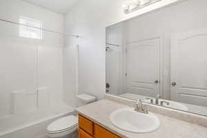 Full bathroom with bathing tub / shower combination, toilet, and vanity