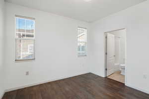 Unfurnished bedroom featuring ensuite bath and tile patterned flooring