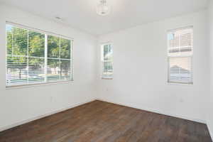 Empty room featuring dark wood-type flooring