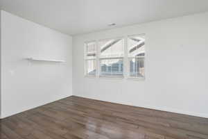 Empty room with dark hardwood / wood-style floors