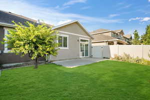 Back of property featuring a yard and a patio area