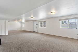 Spare room featuring a textured ceiling and carpet flooring