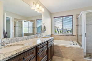 Bathroom featuring double vanity, tile patterned flooring, plus walk in shower, and plenty of natural light