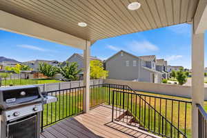 Deck featuring area for grilling and a lawn