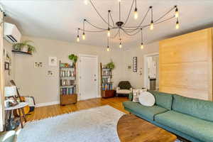 Living room with a wall unit AC and hardwood / wood-style floors