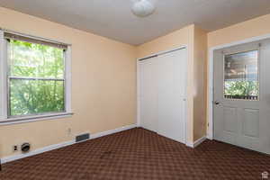 Unfurnished bedroom featuring dark carpet and a closet