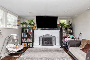 Living room featuring plenty of natural light, a fireplace, and dark hardwood / wood-style floors