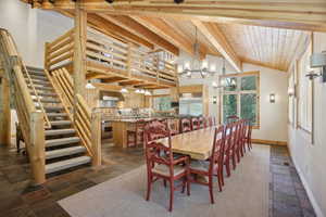 Tiled dining space featuring wood ceiling and a chandelier