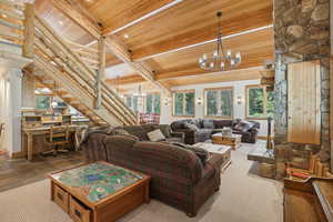 Living room featuring wooden ceiling, rustic walls, beamed ceiling, an inviting chandelier, and tile patterned flooring