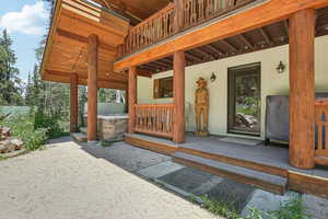 View of exterior entry featuring a patio and a wooden deck