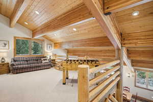 Game room with a healthy amount of sunlight, vaulted ceiling with beams, carpet floors, and wooden ceiling